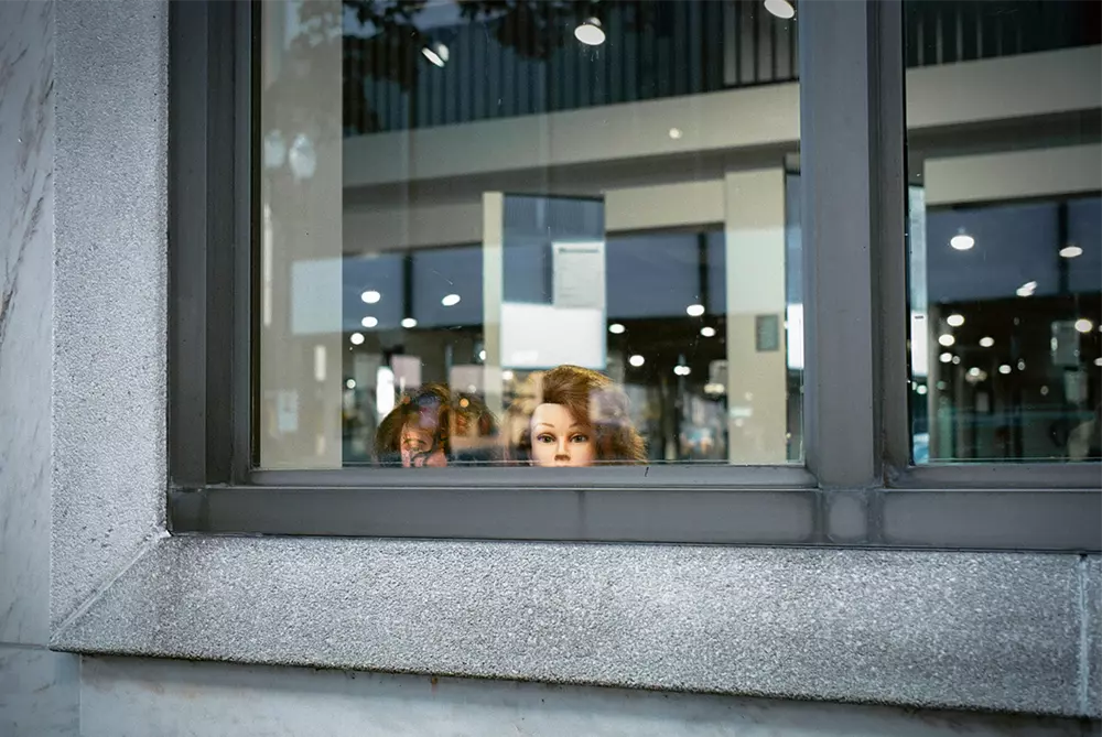 Mannequin heads staring out a window